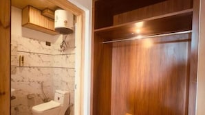 A bathroom with a toilet, a sink, and a shower area. - Milam Hostel (Leh)