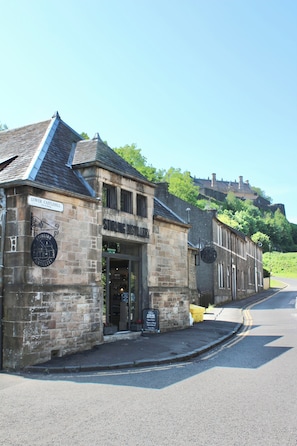 Un edificio de piedra con un letrero que dice 'Lower Castlehill' y 'Strange Distillery'.