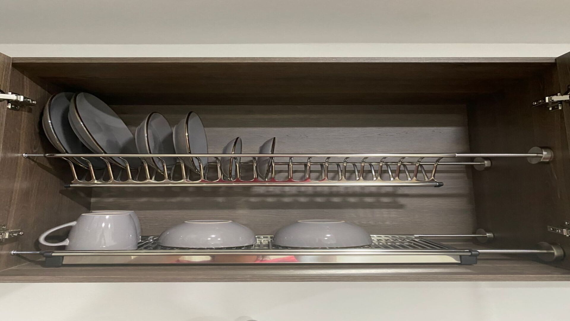 Ein Küchenschrank mit Geschirrhalterung und Besteckbehälter.