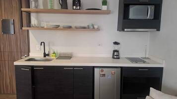 A modern kitchen with a built-in dishwasher, a microwave, and a blender on the countertop.