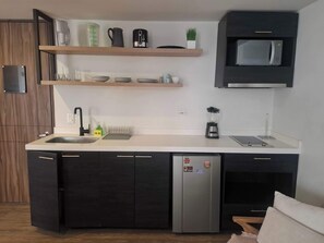A modern kitchen with a built-in dishwasher, a microwave, and a blender on the countertop. - Lourdes Executive Suites 205 (Bogotá)