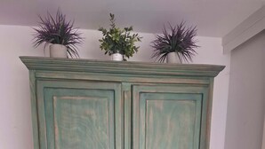 Ein türkisblau gefärbter Schrank mit zwei Türen und einem kleinen Regal obenauf.