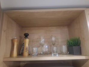 A wooden shelf with various glassware and a small potted plant. - Lourdes Executive Suites 204 (Bogotá)