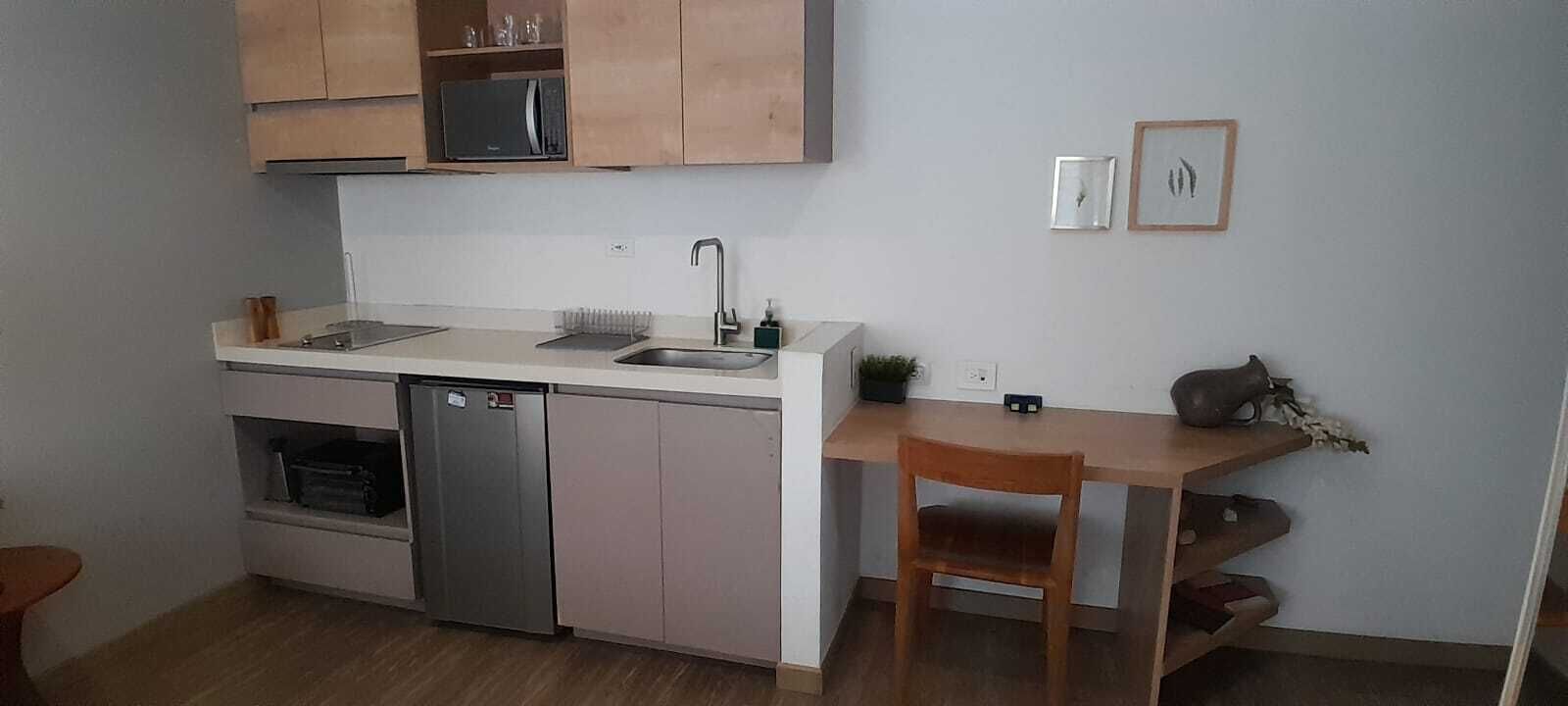 A compact kitchen with a dishwasher, a sink, and wooden cabinets.