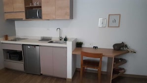 A compact kitchen with a dishwasher, a sink, and wooden cabinets. - Lourdes Executive Suites 203 (Bogotá)