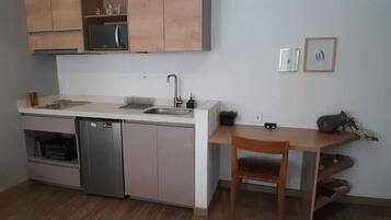A compact kitchen with a dishwasher, a sink, and wooden cabinets.