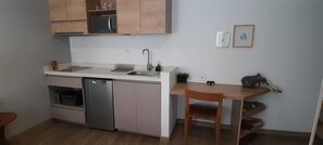 Eine kompakte Küche mit Geschirrspüler, Spüle und Holzschränken.