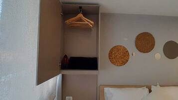 A bedroom with a bed, a hanging rack, and three circular wall decorations.