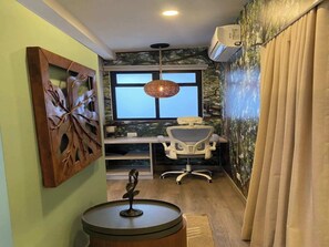 Ein Zimmer mit Schreibtisch, Stuhl und einer dekorativen Metallskulptur.
