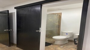 A bathroom with a toilet, a shower, and a sink. - Laureles Executive Suites 104 (Medellín)