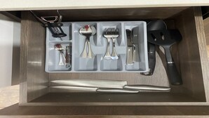 A drawer with a knife, spoon, fork, spatula, and a corkscrew. - Laureles Executive Suites 104 (Medellín)