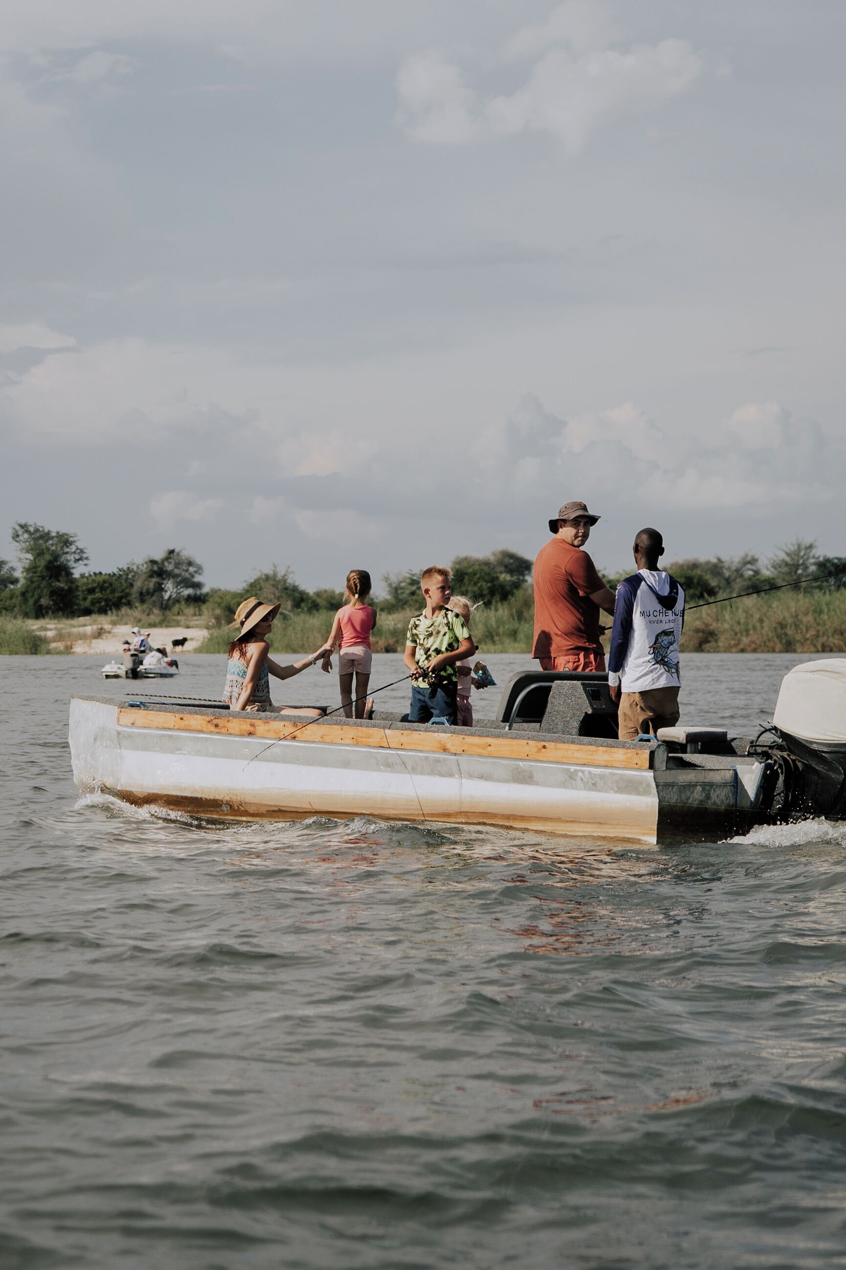 Un grupo de personas en un bote pequeño en el agua, con un cielo nublado al fondo.