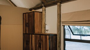 A room with a wooden cabinet, a window, and a wooden floor.