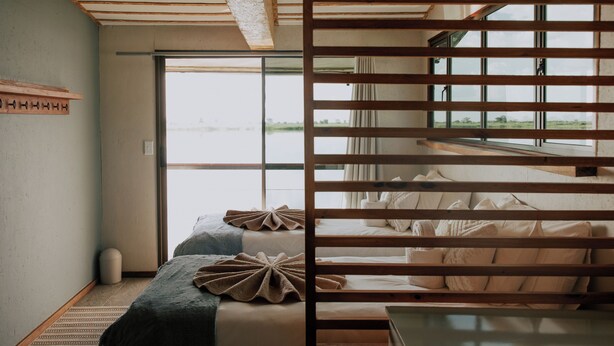 A room with a bed, a window, and a view of the outdoors.