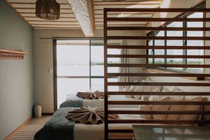 Una habitación con cama, ventana y vistas al exterior.