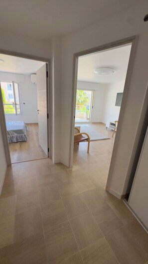 Ein Flur mit einem Bett, einem Sessel und einem Schreibtisch in einem Zimmer.