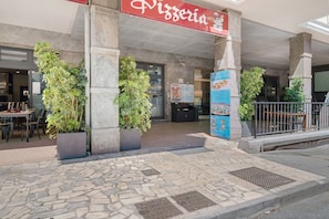 A pizzeria with outdoor seating, stone flooring, and potted plants. - Sea & Center - Chiavari Apartment with Sea View, Wi-Fi, and Air Conditioning (Chiavari)