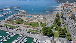 Ein Yachthafen mit vertäuten Booten, ein Strandbereich und eine Stadtansicht mit Gebäuden.