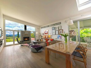 A spacious living room with a fireplace, large windows, and a dining area. - Villa among vineyards with pool near Conero (San Marcello)