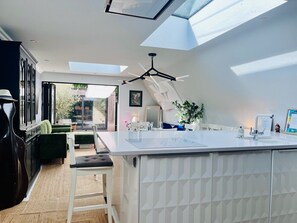A modern kitchen with a large island, skylights, and a view of the outdoors. - Beautiful Cambridge Home by Midsummer Common (Cambridgeshire)