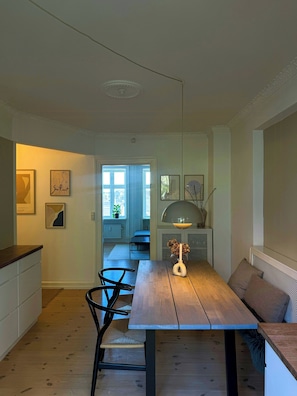 Ein Essbereich mit Holztisch, Stühlen, einer Lampe und einer Bank.