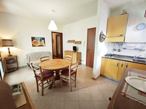 Cocina compacta con una mesa de comedor, sillas, estufa y armarios.