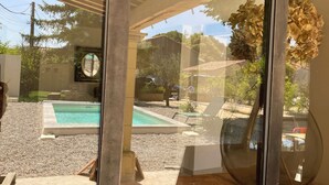 A modern house with a glass door, a pool, and a covered patio area. - A house in Provence. (Camaret-sur-Aigues)