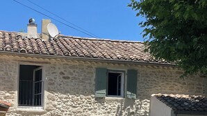 A stone building with a swimming pool, outdoor seating, and a clear blue sky. - A house in Provence. (Camaret-sur-Aigues)