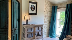 A room with a bed, a cabinet, a framed picture on the wall, and a window with curtains. - A house in Provence. (Camaret-sur-Aigues)