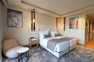 Ein Hotelzimmer mit einem Doppelbett, einem Nachttisch, einem Sessel und Bildern an den Wänden.