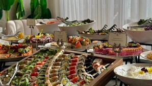 Un bufé con diversos alimentos y una planta decorativa.