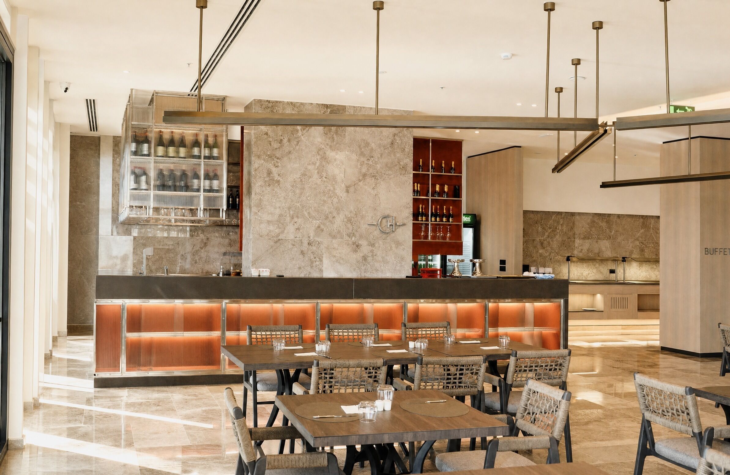 Un moderno vestíbulo de hotel con zona de bar, asientos y mostrador de recepción.