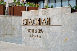 Un letrero de hotel con el nombre 'CHAONIAN' y 'HOTEL & SPA', indicando el nombre y los servicios del establecimiento.