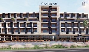 A modern hotel with a central tower, multiple balconies, and a pool area with sun loungers. - CHAONIAN Hotel (Himare)