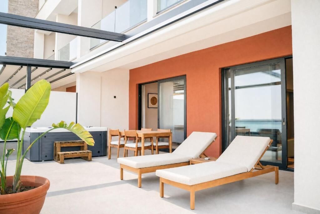 Uma área de estar moderna ao ar livre, com móveis de madeira e um vaso com planta.