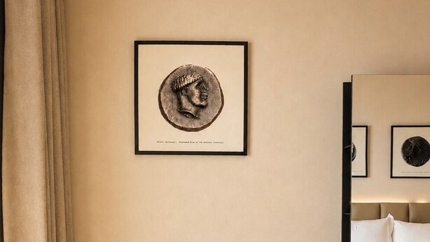 A room with a sofa, a bed, and a framed picture on the wall. - CHAONIAN Hotel (Himare)