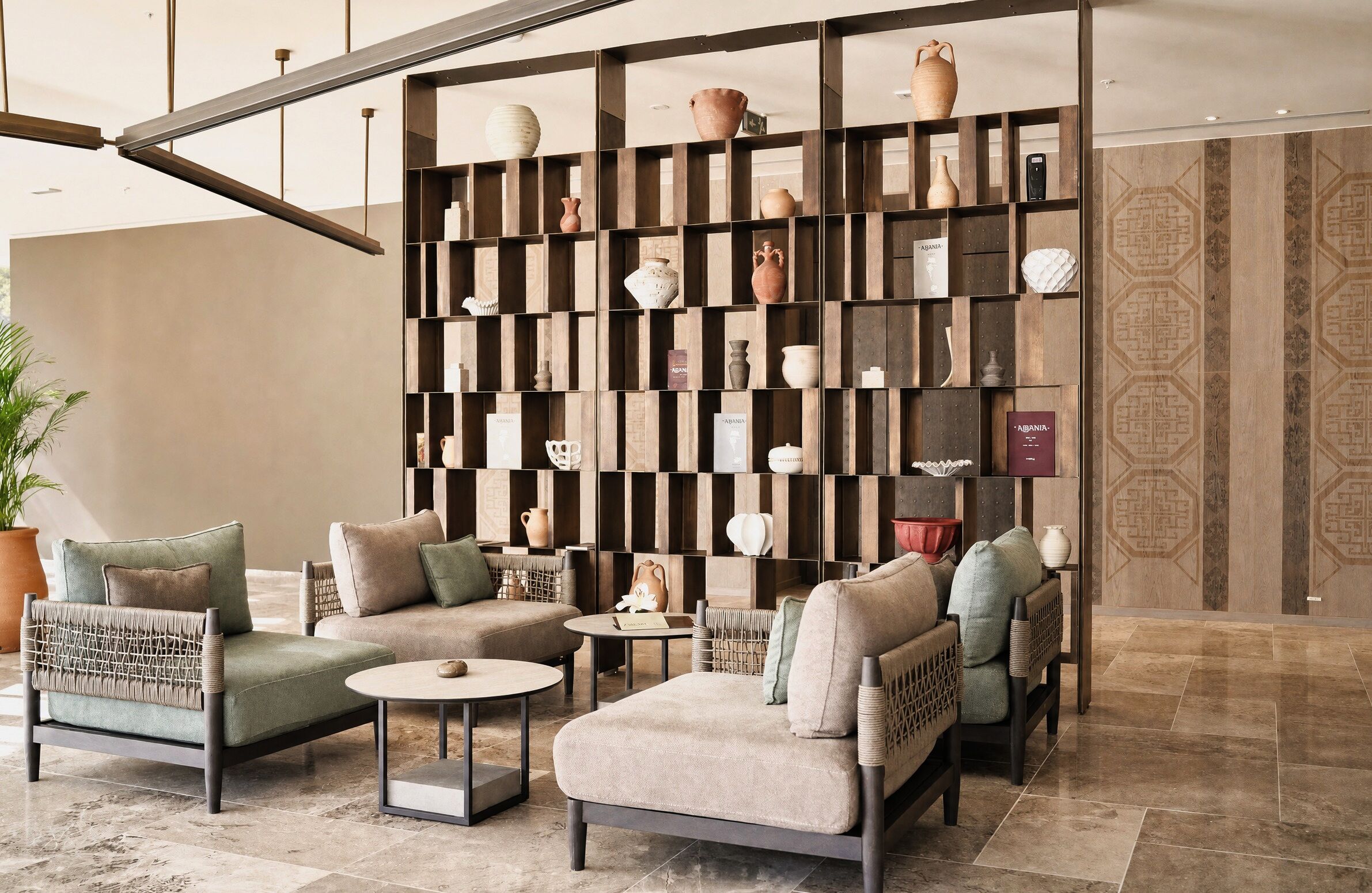 A modern lounge area with sofas, a coffee table, and a decorative wall with pottery.