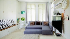 A modern living room with a grey sofa, a flat-screen TV, and a white cabinet. - TLV Market Apartment (tel aviv)