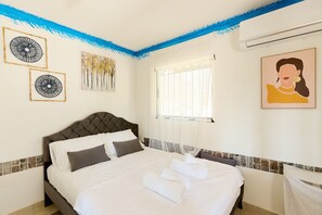 A neatly made bed with white linens, a tufted headboard, and two wall art pieces. - pRETTyHome with private swimming pool,sea view,private parking,bbq,free wifi (χαλκιδικη)