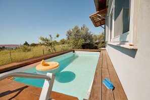A swimming pool with a wooden deck, a lifebuoy, and a pool brush. - pRETTyHome with private swimming pool,sea view,private parking,bbq,free wifi (χαλκιδικη)