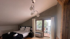 A bedroom with a bed, a radiator, a window with curtains, and a ceiling light fixture. - Florianska DeLux Annex 2-bedroom apartment with AC in Old Town Kraków (Kraków)