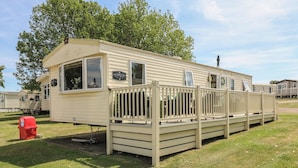 A single-story mobile home with a front porch and a small attached garage.