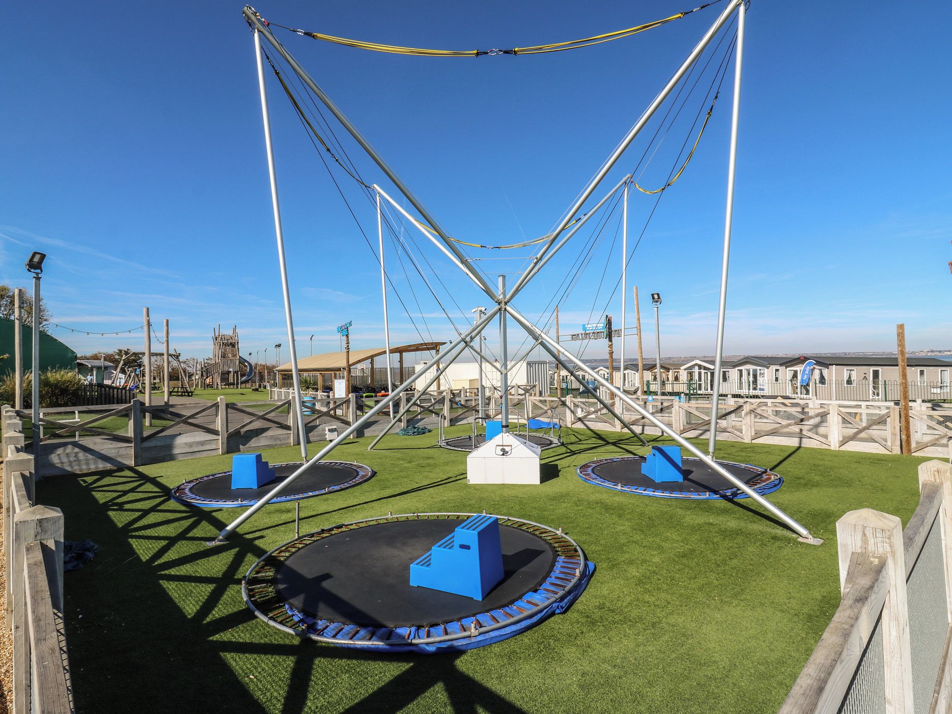 A playground with multiple trampolines and a climbing structure.