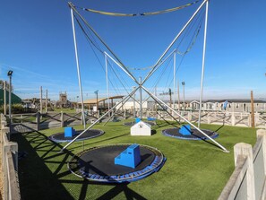 Un parque infantil con varios trampolines y una estructura para escalar.