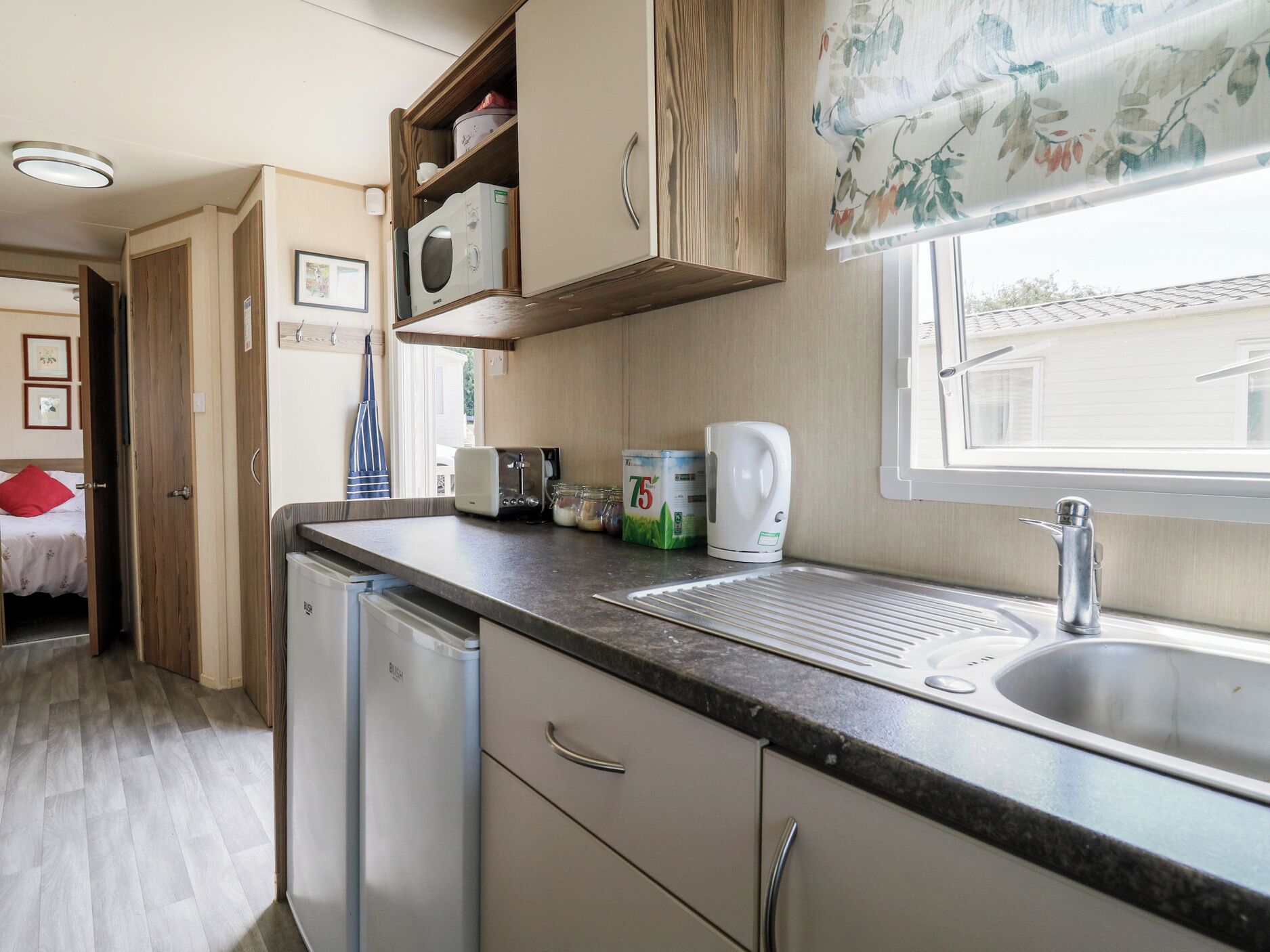 A compact kitchenette with a sink, a microwave, and a small refrigerator.