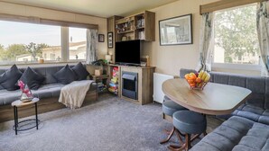 Ein gemütliches Wohnzimmer mit einer Couch, einem Esstisch und einem Fernseher.
