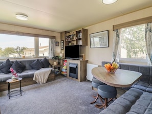 Una sala de estar acogedora con un sofá, una mesa de comedor y una televisión.