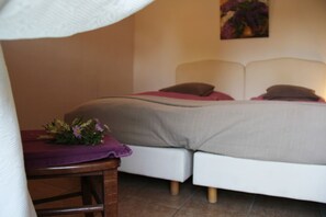 Une chambre à coucher avec un lit, des oreillers, une table de chevet et un tableau au mur.