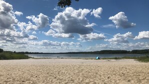 En sandstrand med et telt og en klar himmel.