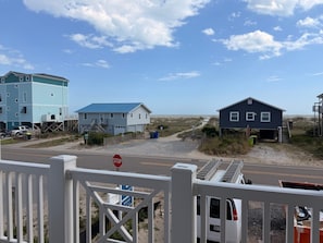 Ein Anwesen am Strand mit einem Stoppschild, einem blauen Haus und einem hölzernen Steg, der sich ins Wasser erstreckt.